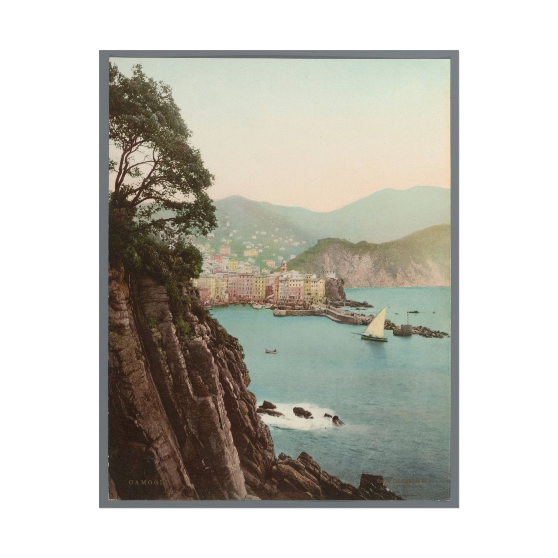 Scenic coastal view of Camogli, Italy, with cliffs and sailboats.