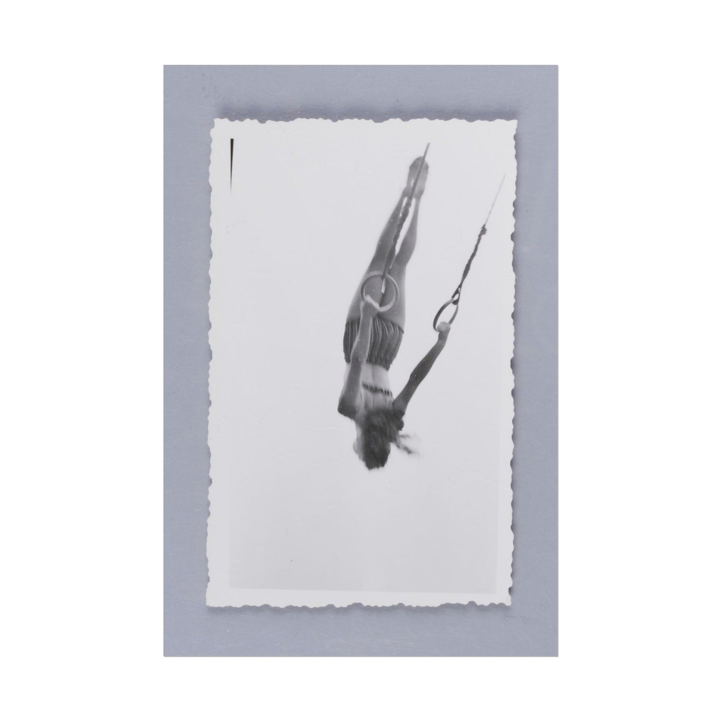 A woman performing acrobatics on rings in black and white.