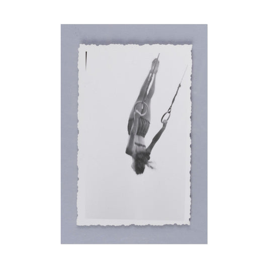 A woman performing acrobatics on rings in black and white.