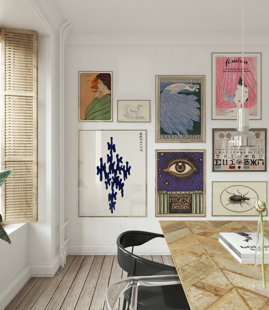 Modern interior with a wall displaying various framed artworks and a dining table.